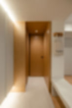 Bright hallway with wood paneling and beige tiles, a fabric bag labeled "Parallel 51" hangs on wooden hooks, modern minimalist design.