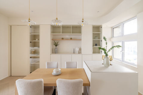 Modern dining room interior design by MAD Studio featuring minimalist furniture and elegant decor. Light-filled space with glass pendant lighting, wooden dining table, and contemporary shelving. Perfect blend of style and functionality for a chic, sophisticated home. Expert interior design services for modern living spaces.