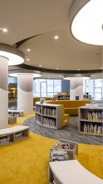 PRIMARY LIBRARY, VSA, Kindergarten Design
Modern library interior design by MAD Studio featuring circular architectural elements and contemporary lighting. The space showcases curved bookshelves, vibrant yellow carpeting, and natural light from large windows, creating a welcoming and stylish environment. Ideal for innovative interior design enthusiasts.